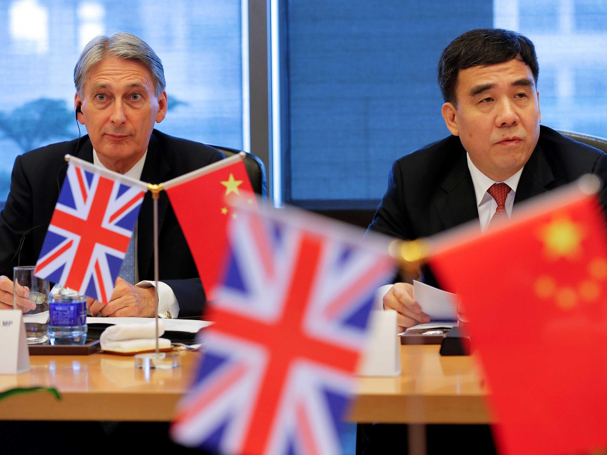 Britain's Chancellor of the Exchequer, Philip Hammond (L) and Bank of China Chairman Tian Guoli attend UK-China High Level Financial Services Roundtable at the Bank of China head office building in Beijing, China July 22, 2016
