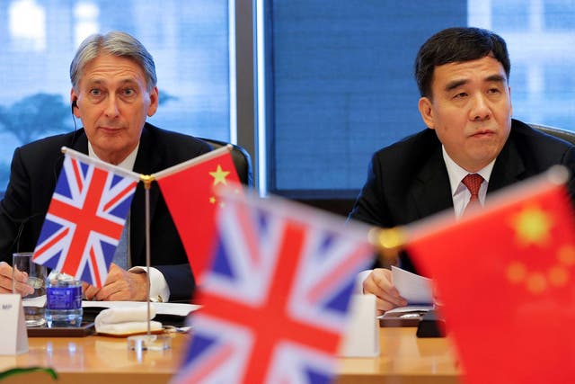 Britain's Chancellor of the Exchequer, Philip Hammond (L) and Bank of China Chairman Tian Guoli attend UK-China High Level Financial Services Roundtable at the Bank of China head office building in Beijing, China July 22, 2016