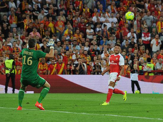 Alex Oxlade-Chamberlain watches his chip sail over Douchez to equalise for Arsenal in Lens (Getty)