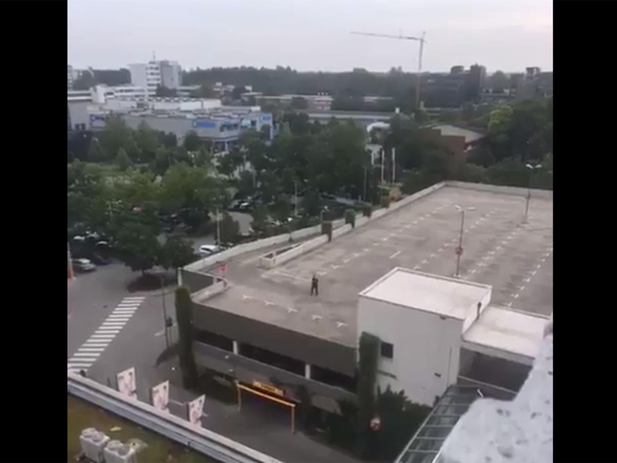 The gunman pictured on the roof of a building