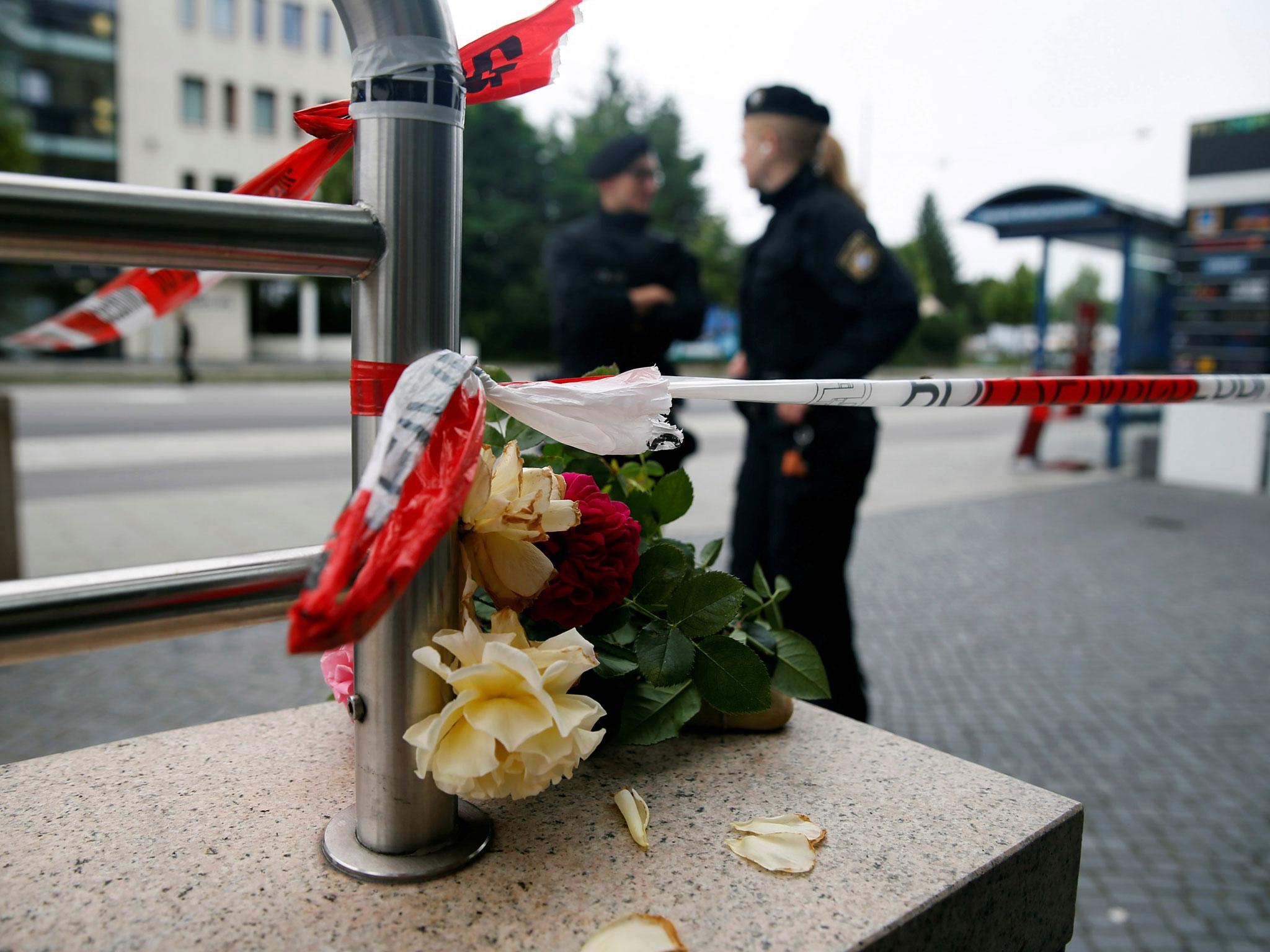 Flowers are placed near the Olympia shopping mall, where nine people were killed in Munich, Germany