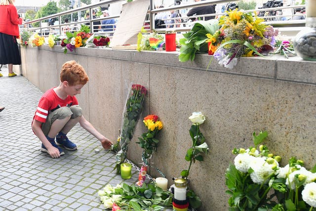 Mourners lay flowers near the OEZ mall where a shooting took place leaving nine people dead