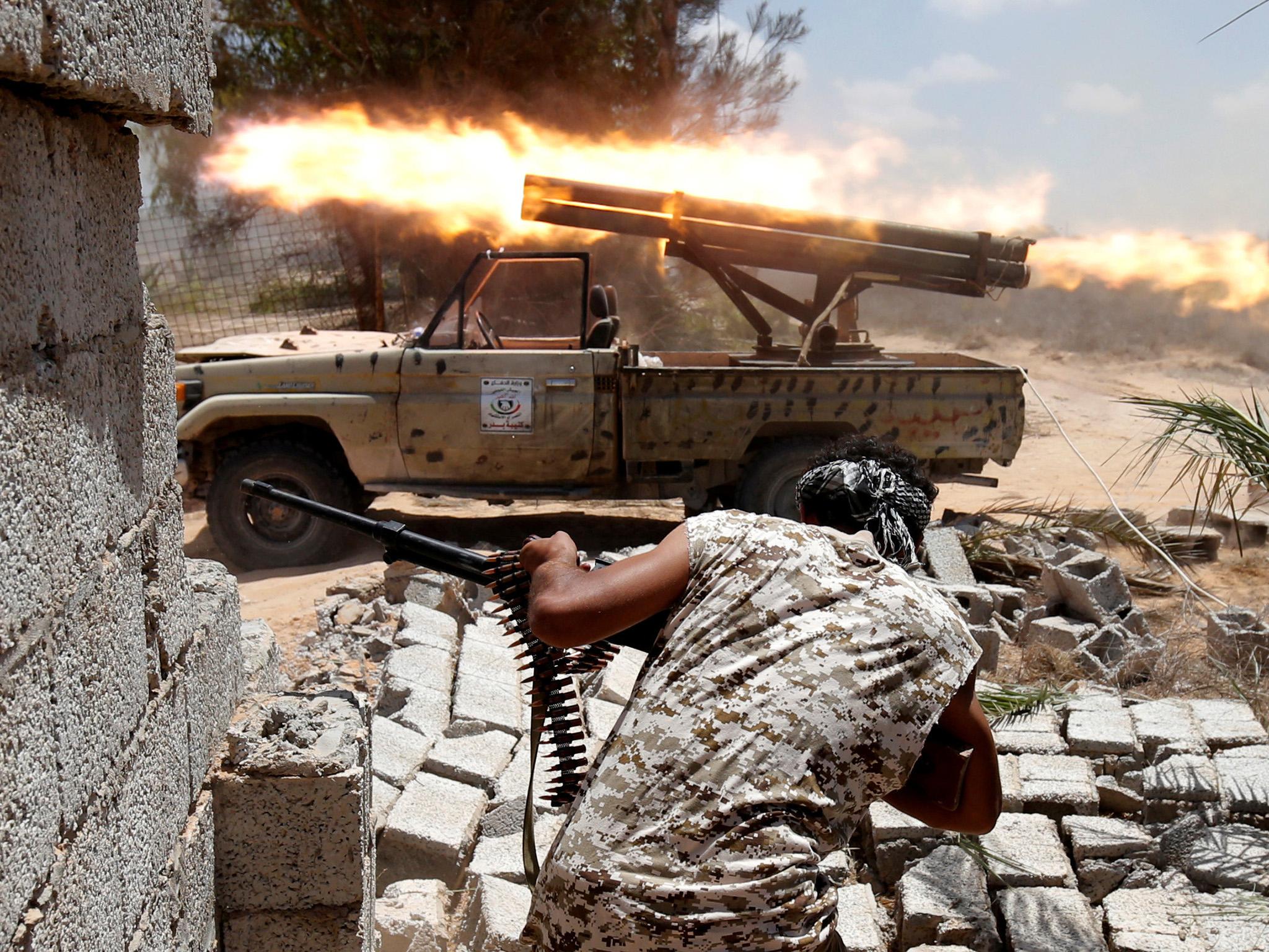 Libyan forces allied with the U.N.-backed government fire weapons during a battle with IS fighters in Sirte, Libya