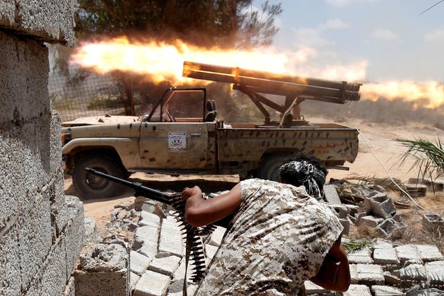 Libyan forces allied with the U.N.-backed government fire weapons during a battle with IS fighters in Sirte, Libya