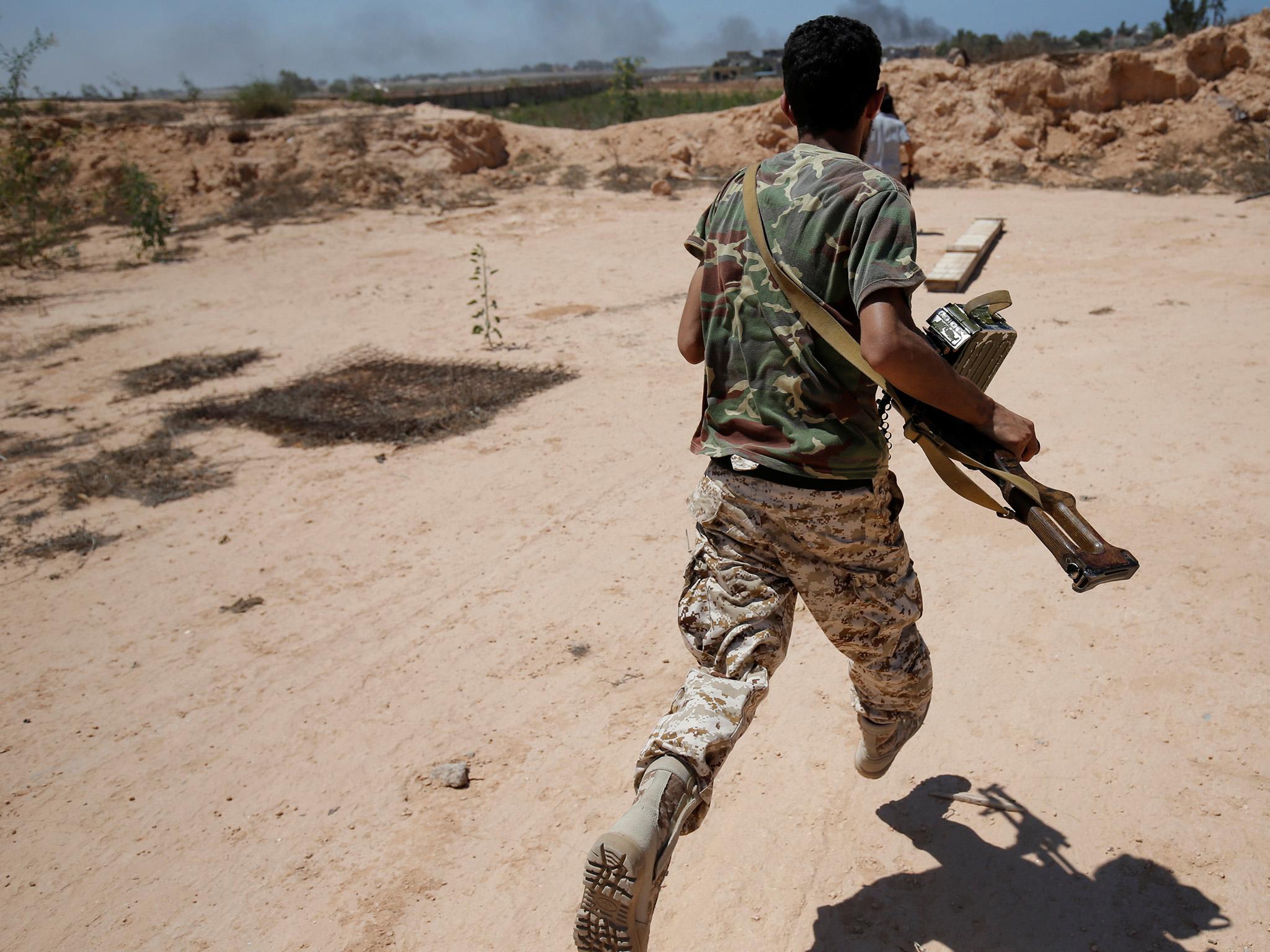 &#13;
A Libyan fighter runs for cover during a battle with Isis fighters in Sirte &#13;