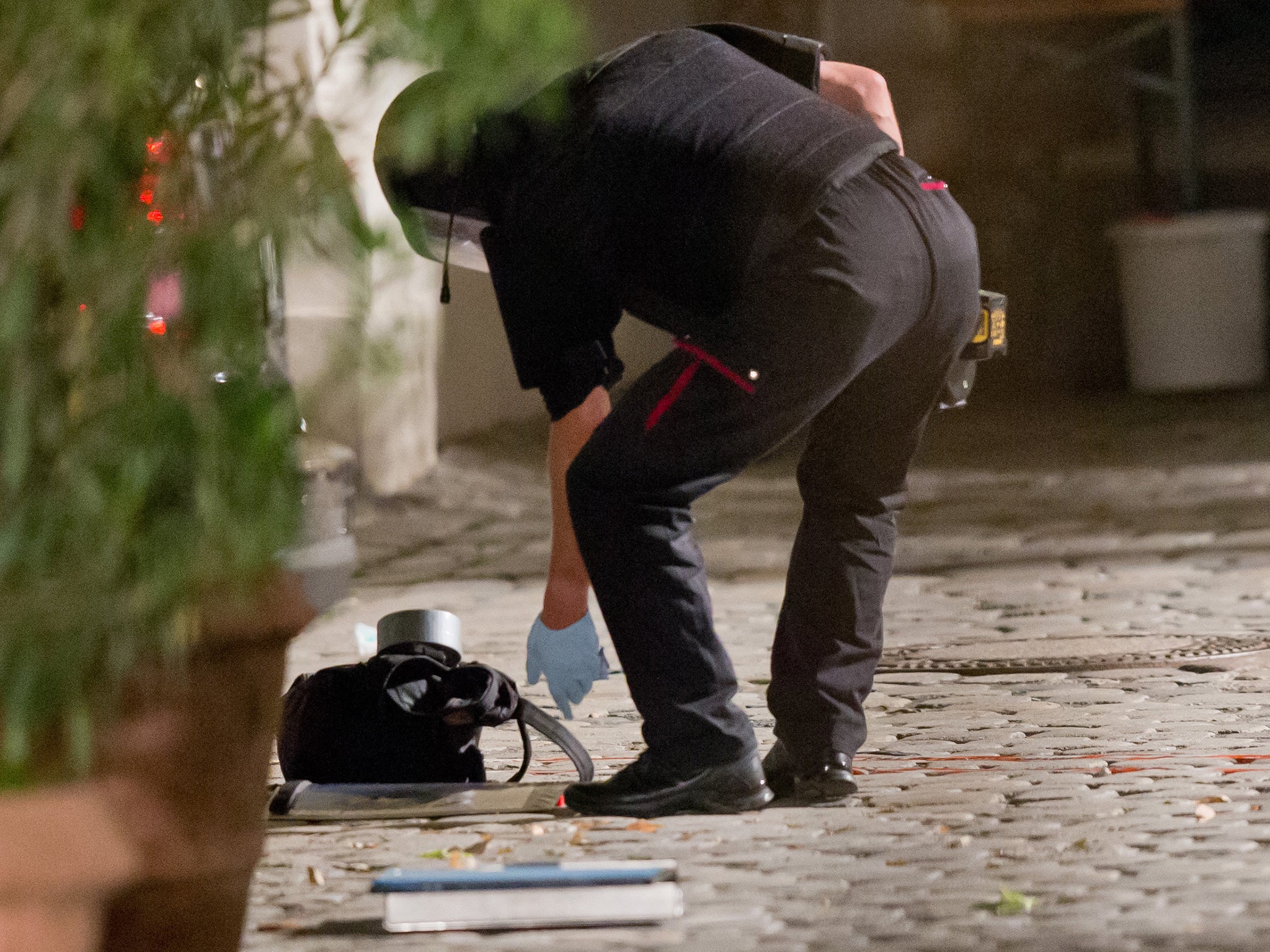 A police officer inspects a backpack used to carry an explosive device at the scene of the attack in Ansbach