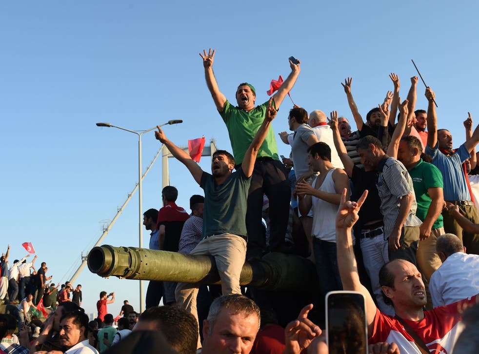 Civilians climb onto tanks after taking over military rebels' position on the Bosphorus bridge in Istanbul