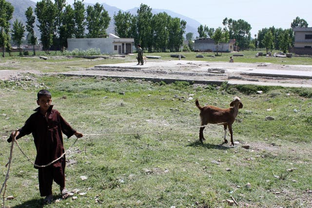 A Pakistani young boy walks with his goat at the site of the demolished compound of slain Al-Qaeda leader Osama bin Laden in Abbottabad.