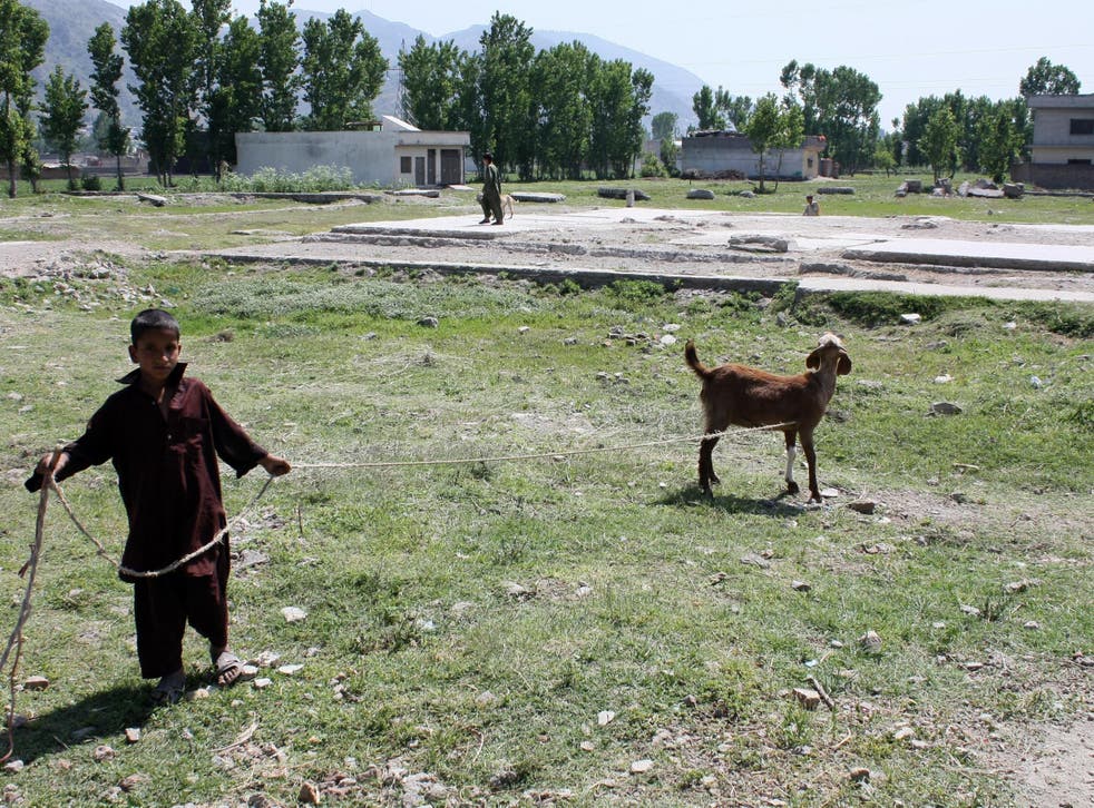 A Pakistani young boy walks with his goat at the site of the demolished compound of slain Al-Qaeda leader Osama bin Laden in Abbottabad.