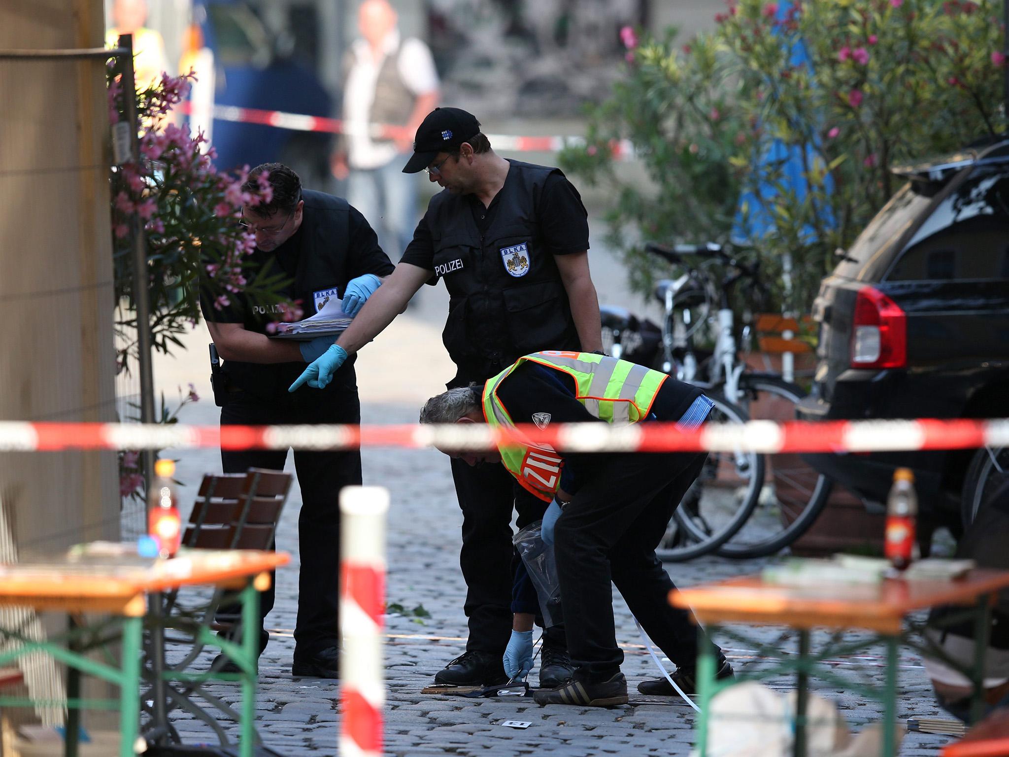 Police officers operate on a scene following an explosion in Ansbach, Germany,