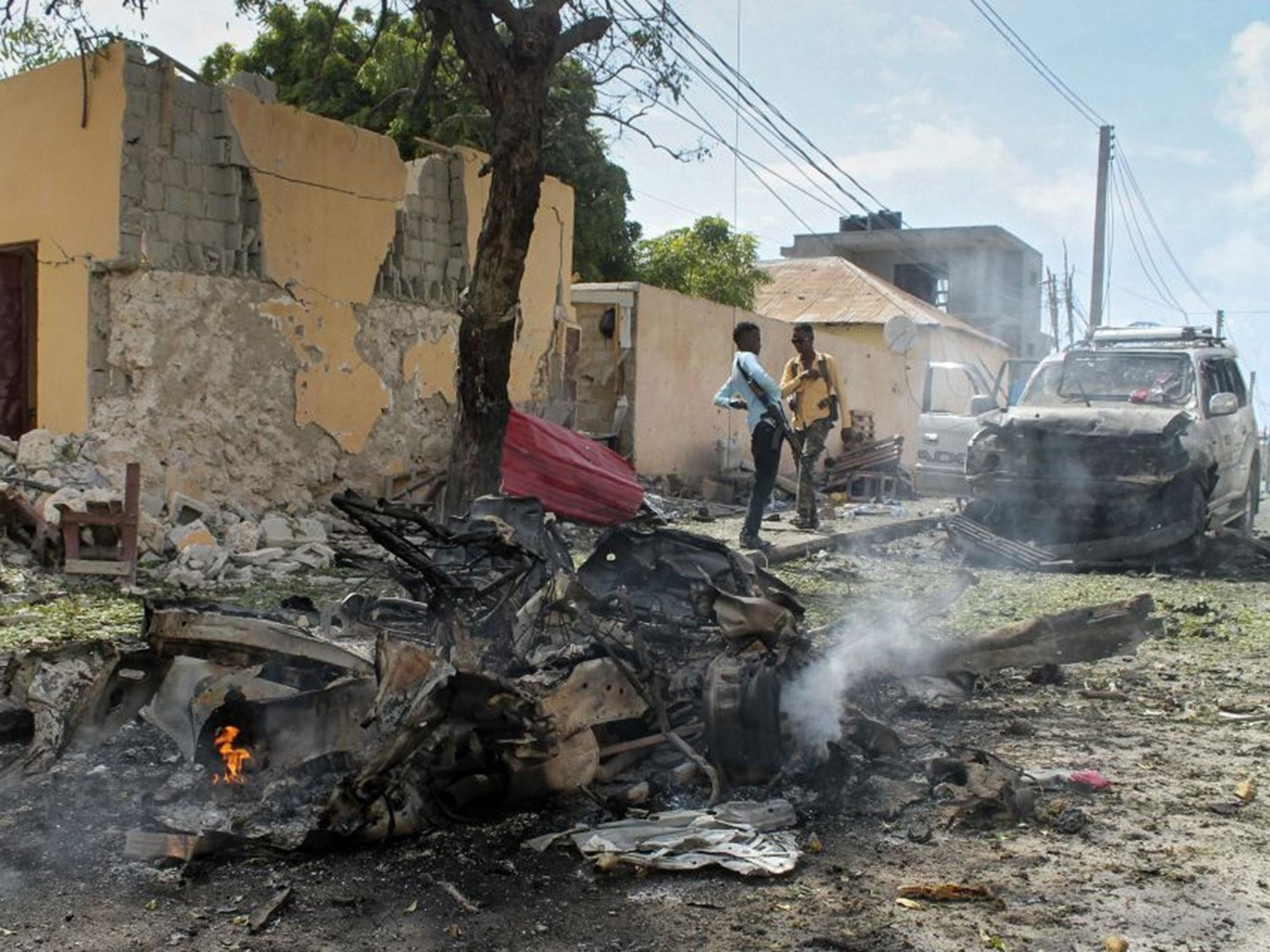 Somali security officers gather at the scene of a car bomb attack at the base for the African Union forces in Mogadishu, Somalia, 26 July, 2016