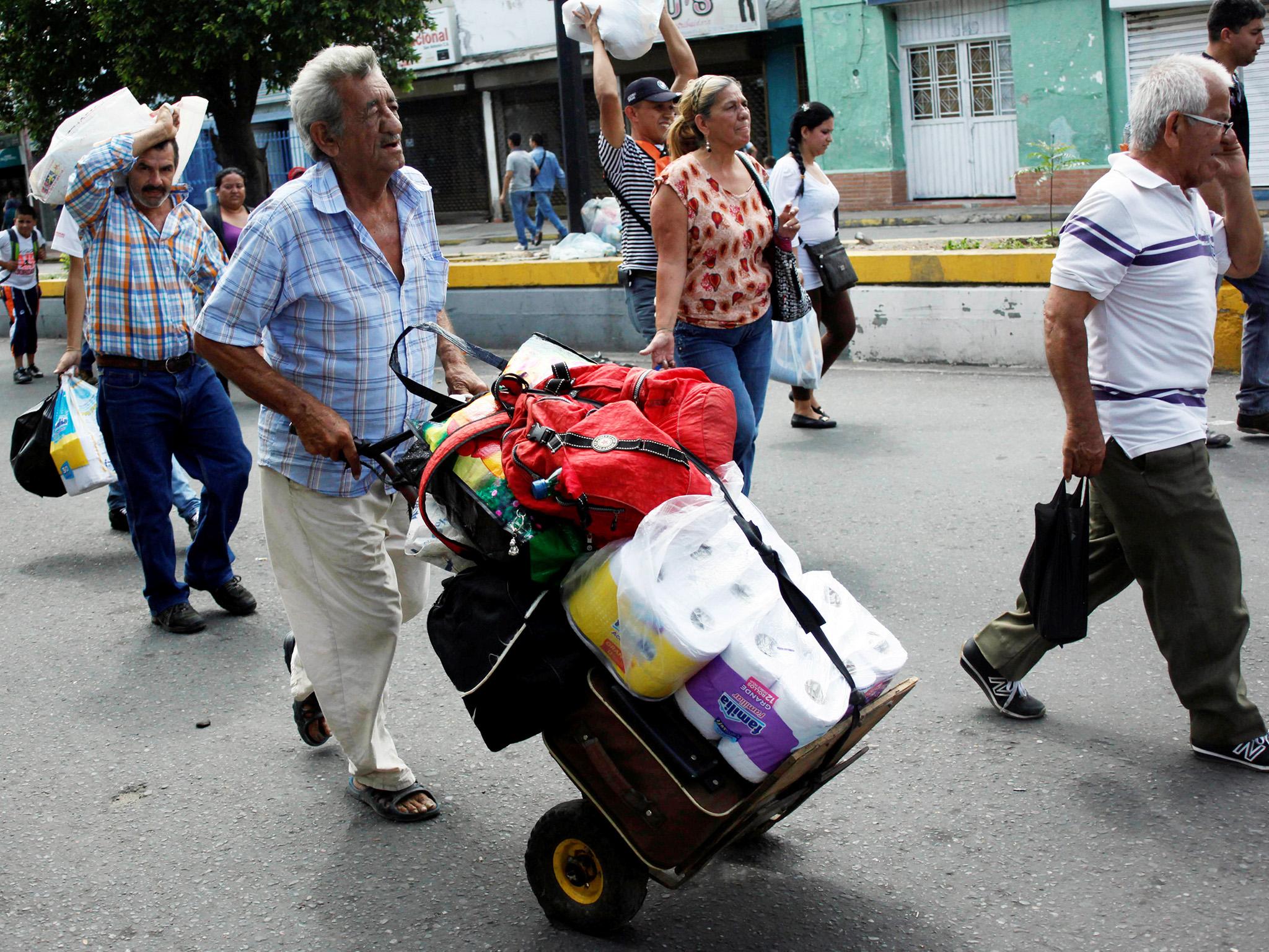 A man pushes a trolley with toilet paper and other goods as he walks towards the Colombian-Venezuelan border after shopping in Cucuta, Colombia