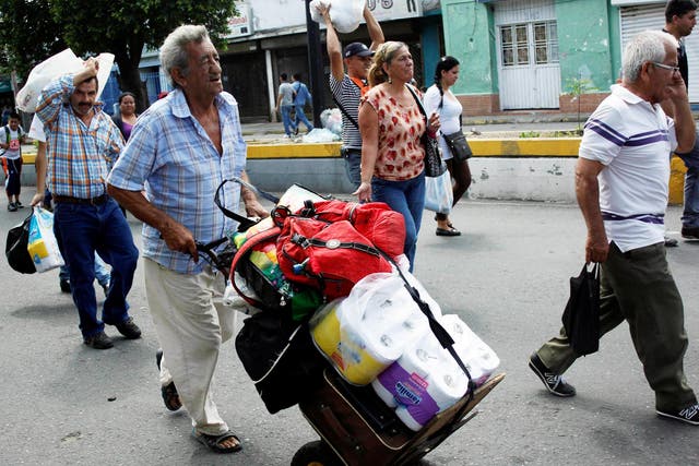 A man pushes a trolley with toilet paper and other goods as he walks towards  the Colombian-Venezuelan border after shopping in Cucuta, Colombia