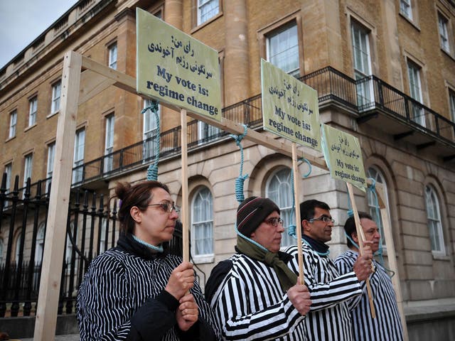 Iranian opposition protesters stand through makeshift nooses as they stage a mock execution during a rally against the Iranian regime in central London.