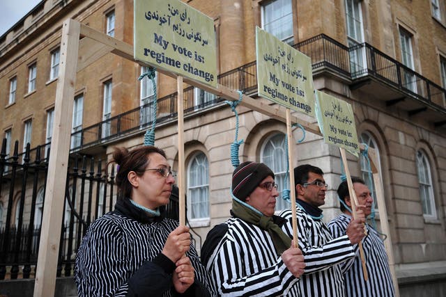 Iranian opposition protesters stand through makeshift nooses as they stage a mock execution during a rally against the Iranian regime in central London.