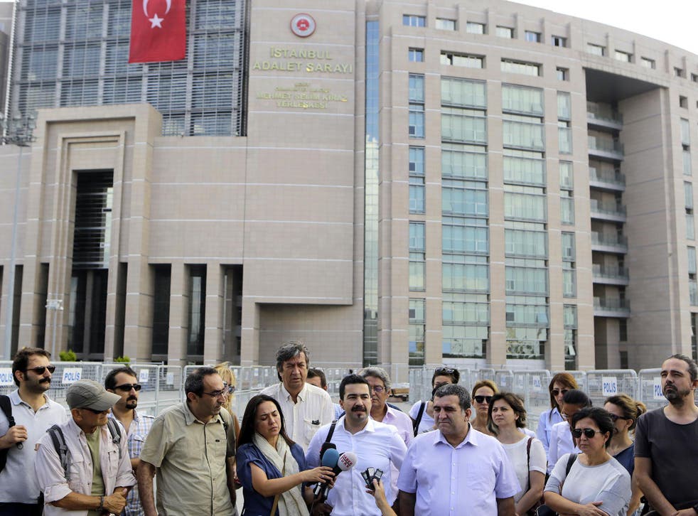 Journalists gather outside a court building to support their colleague Bulent Mumay, who was detained on Tuesday
