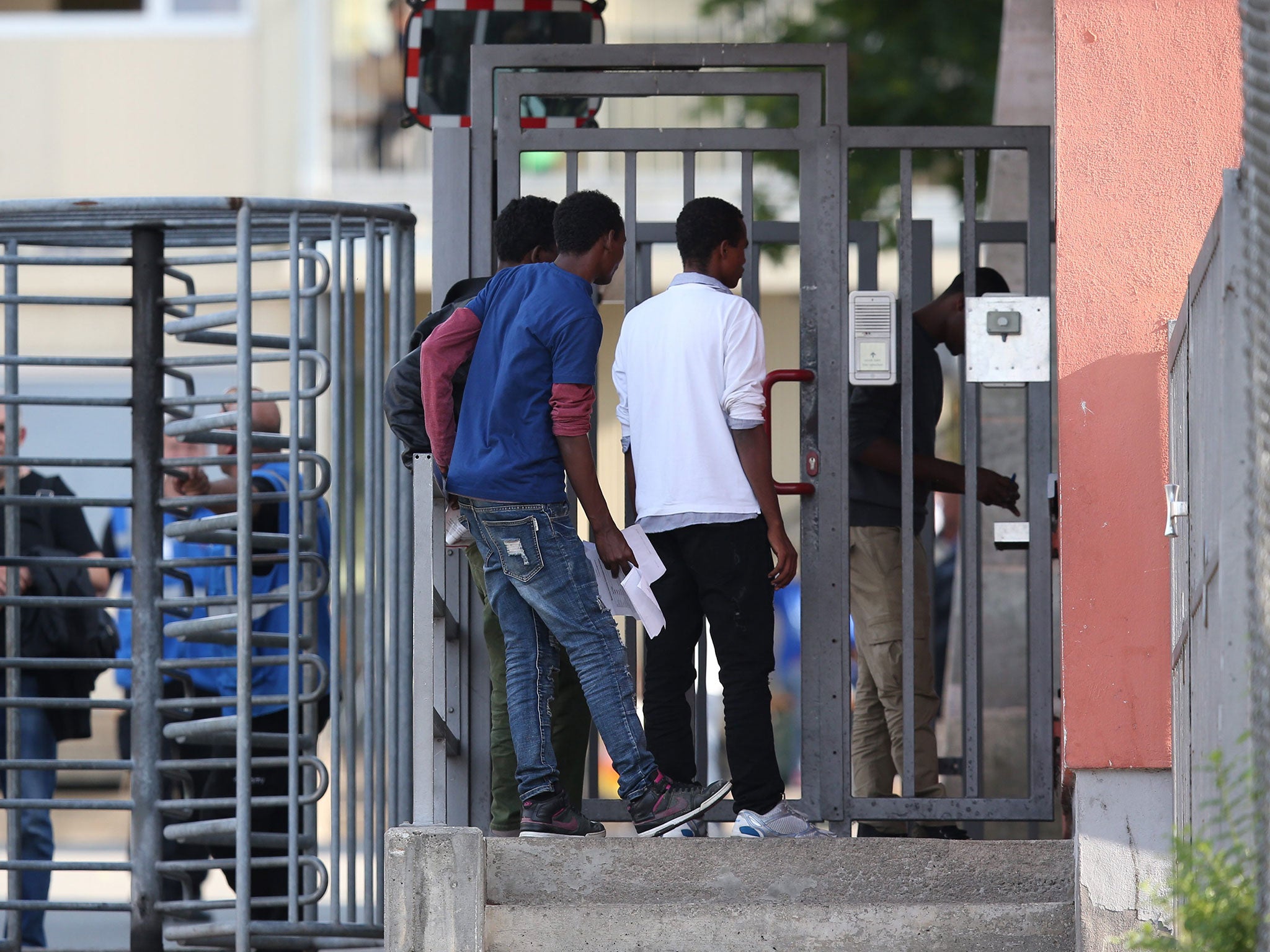 Refugees enter the reception centre for refugees in Zirndorf, after a suitcase exploded near the building on 27 July 2016.