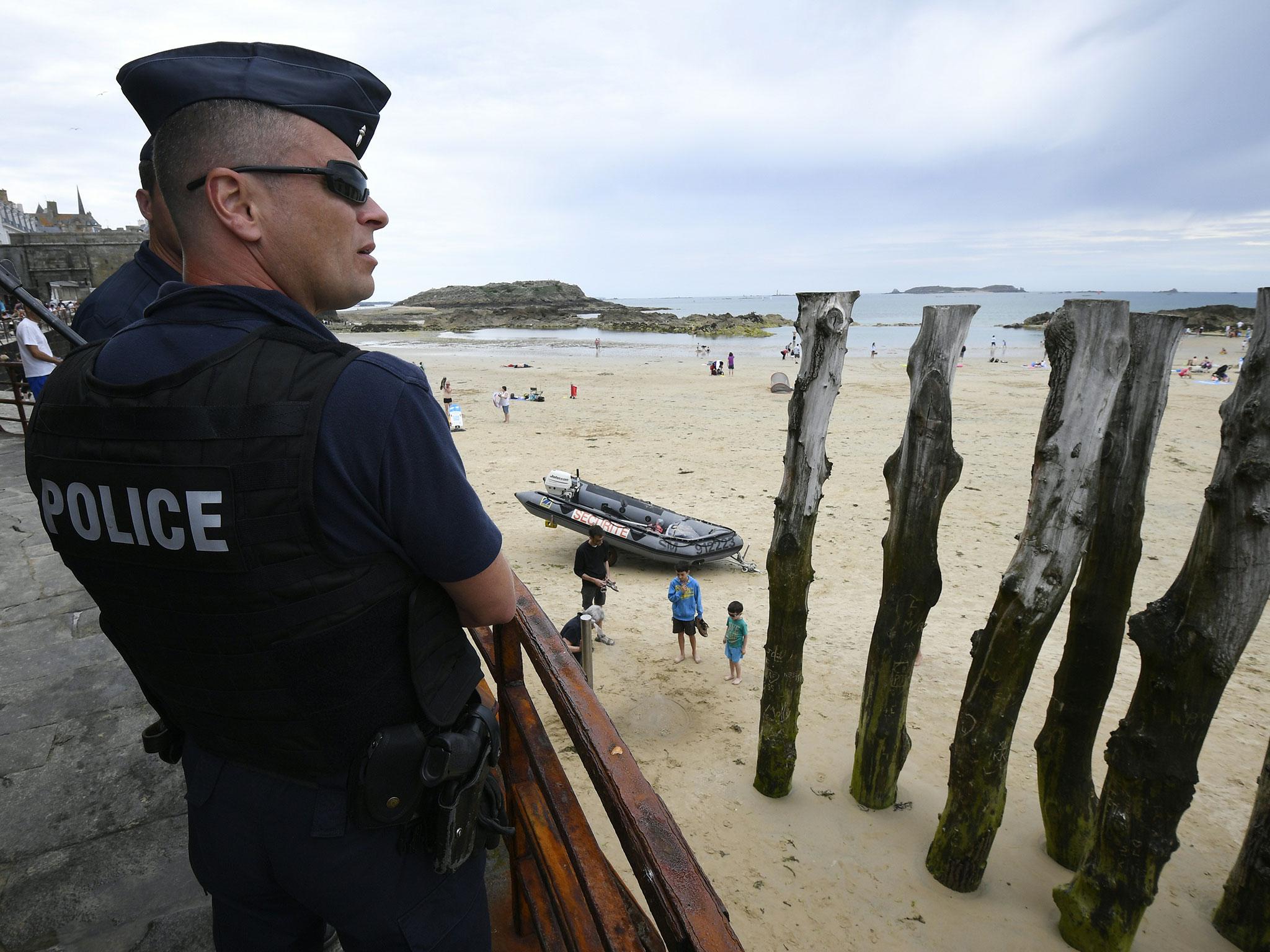 French anti-riot policemen (CRS - compagnie Republicaine de Securite) patrol close to the beach of Saint-Malo, western France on July 21, 2016