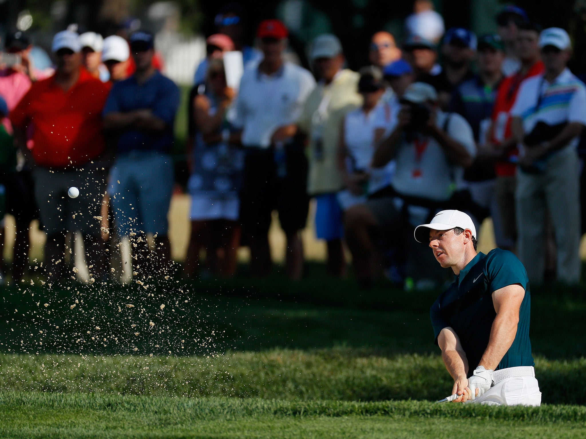 Rory McIlroy hits out of a bunker after making a poor start to his opening round