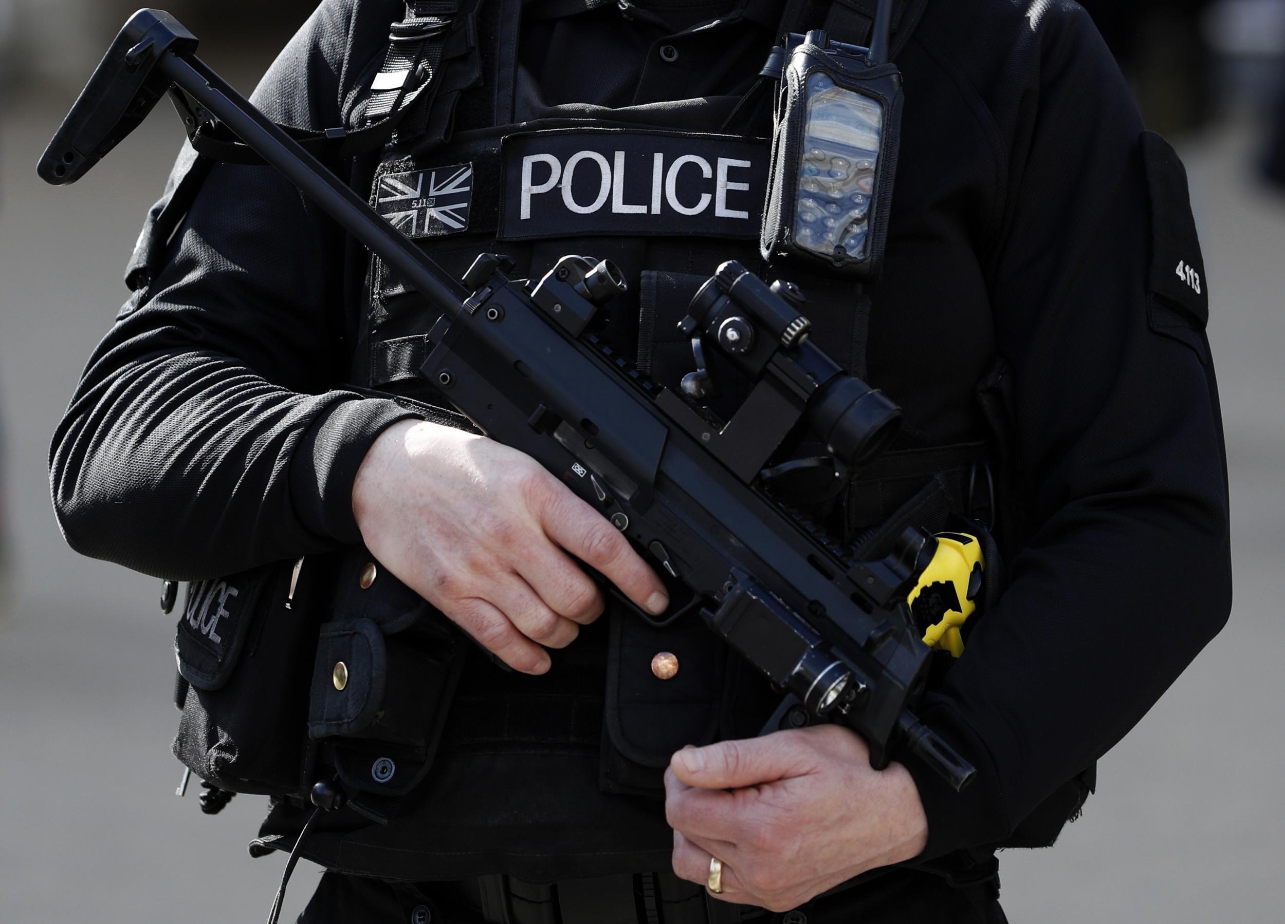 An armed British police officer holds his weapon as he stands on duty in central London in March 2016
