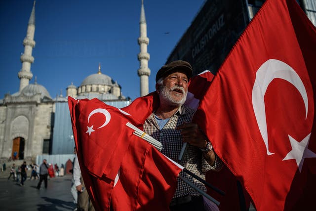 A man sells Turkish flags outside Istanbul's iconic Blue Mosque