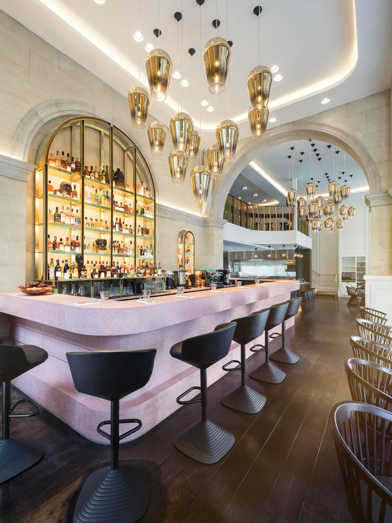 Tom Dixon's pink concrete bar and hanging pendant lights in the entrance