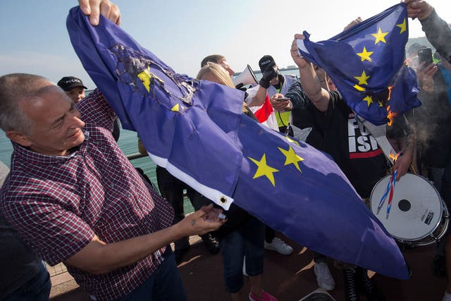 A group of far right protesters burn a European Union flag after a demonstration in Dover