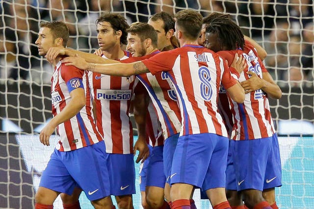 Diego Godin is mobbed by his team-mates after putting Atletico ahead