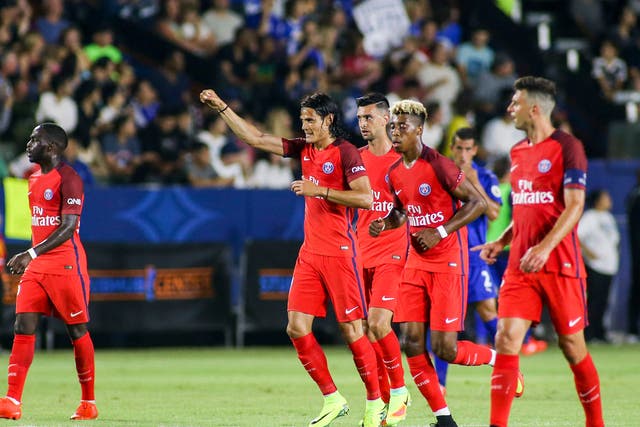 Edinson Cavani celebrates with his PSG teammates after scoring a penalty