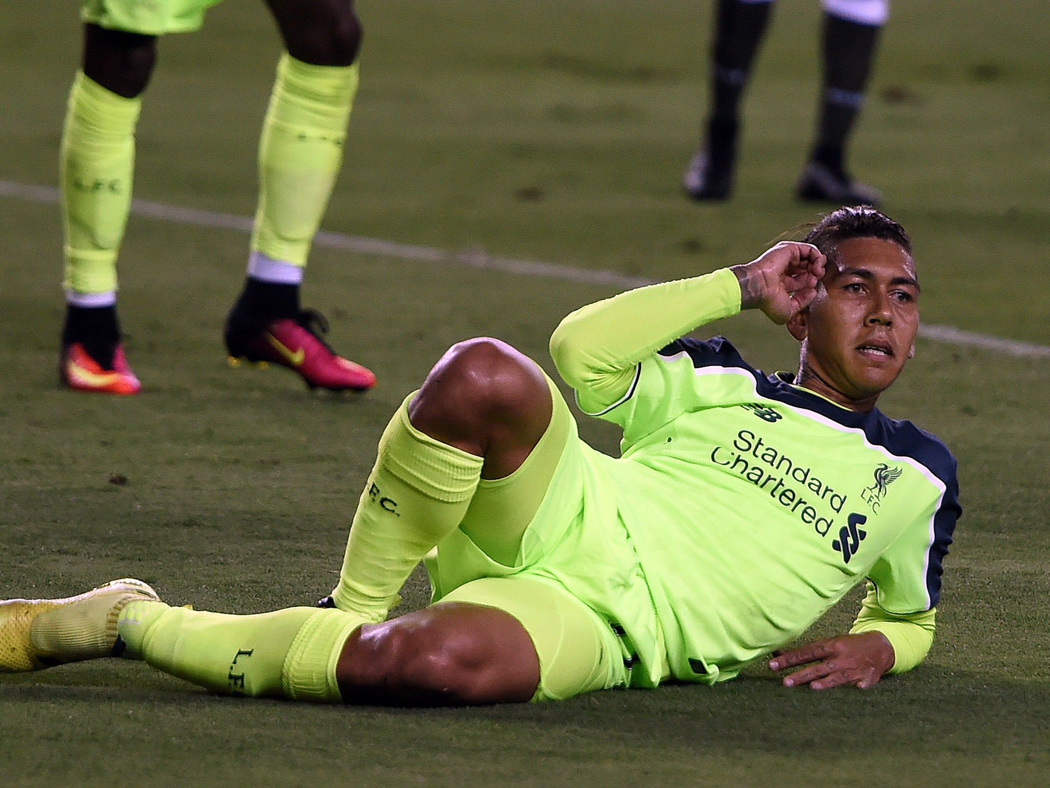 Roberto Firmino slides on the ground to celebrate scoring Liverpool's second goal against AC Milan