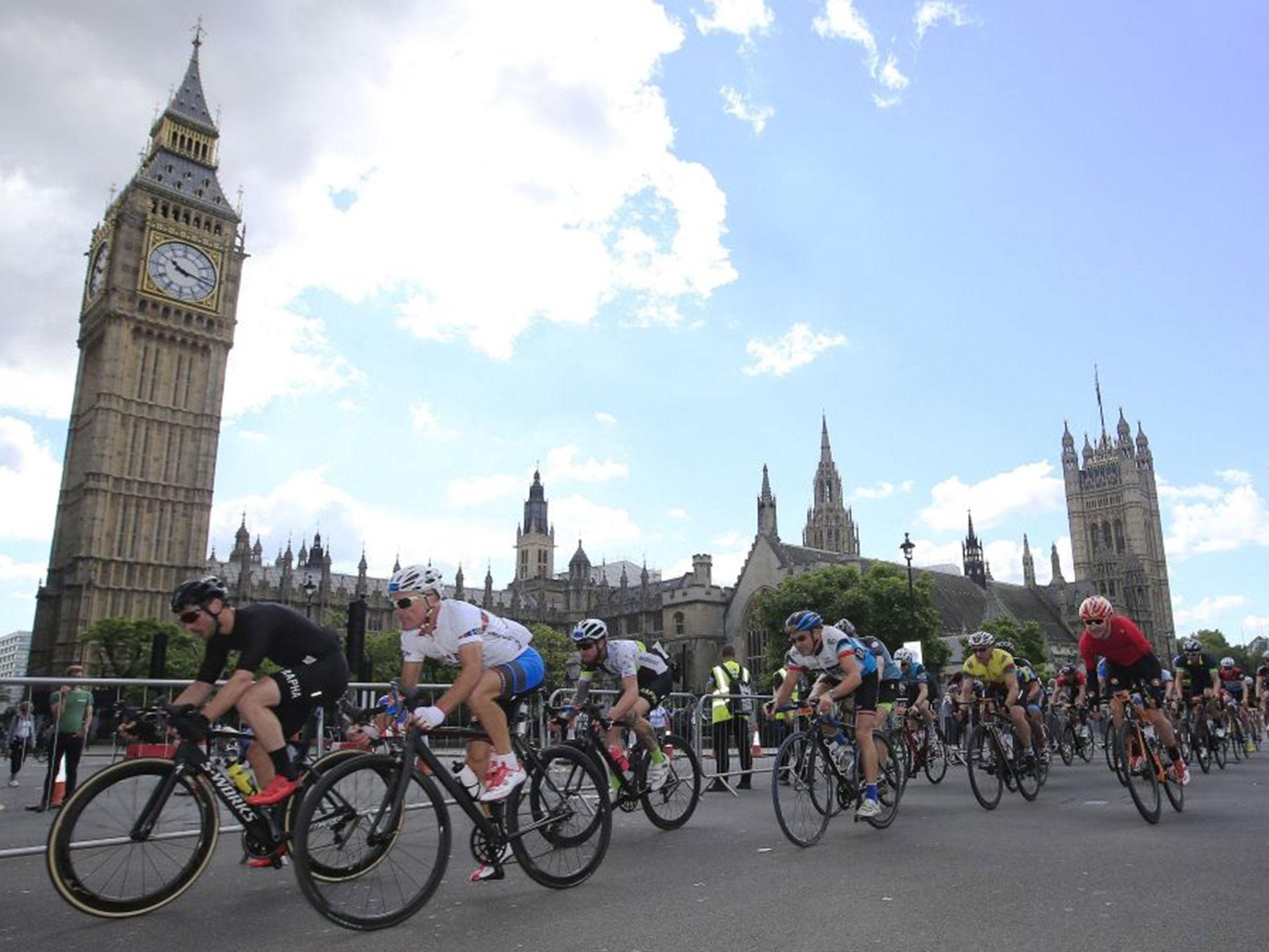 Cyclists pass the Palace of Westminster in the latter stages of the Prudential Ride 100