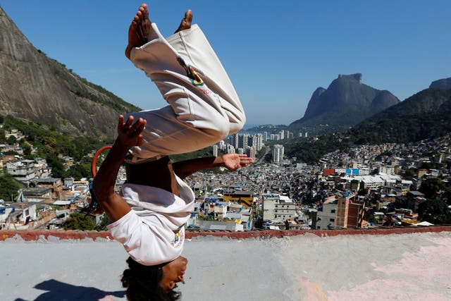 A member of the Acorda Capoeira (Awaken Capoeira) group performs on a rooftop in the Rocinha favela in Rio de Janeiro