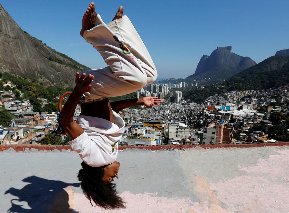 A member of the Acorda Capoeira (Awaken Capoeira) group performs on a rooftop in the Rocinha favela in Rio de Janeiro