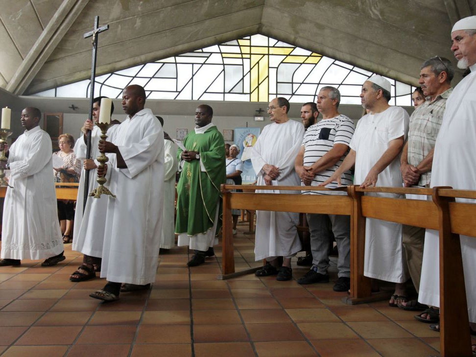 Muslim worshippers stand up as clerics arrive in the Saint-Pierre-de-lAriane church