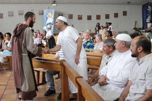 A catholic monk welcomes muslim worshippers in the Saint-Pierre-de-lAriane church