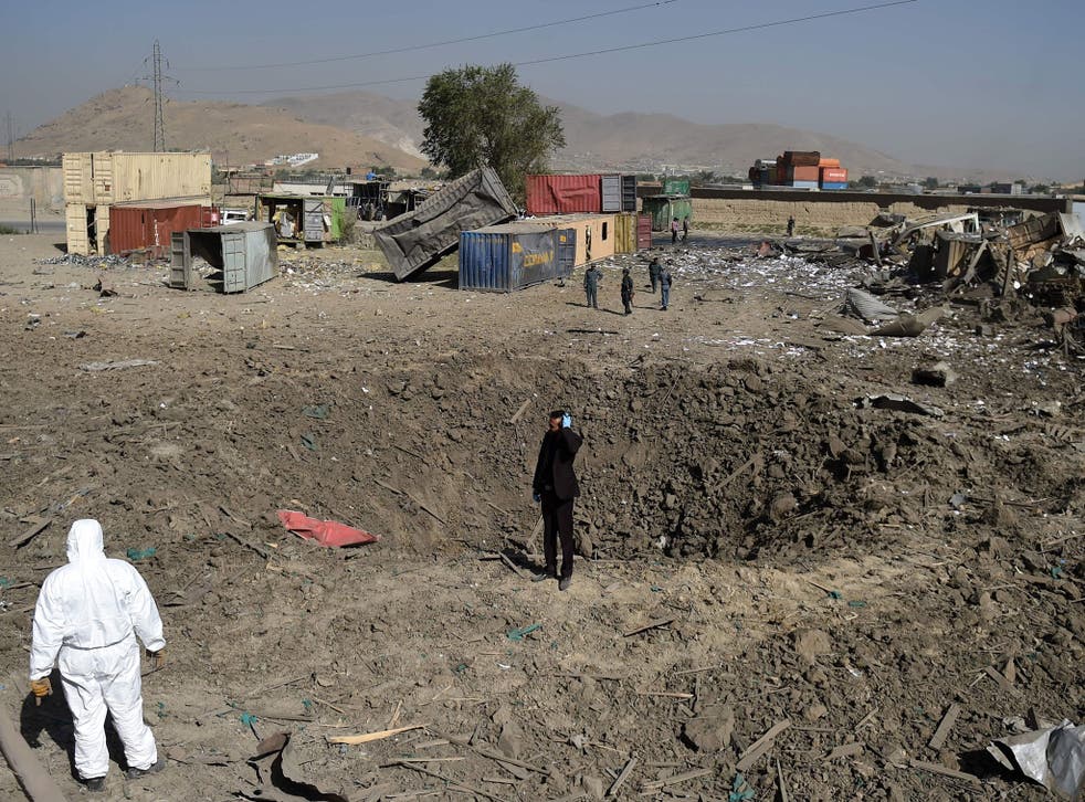 Afghan security personnel stand alert at the site after a powerful truck bomb targeting a hotel used by foreign contractors exploded on the outskirts of Kabul on August 1, 2016