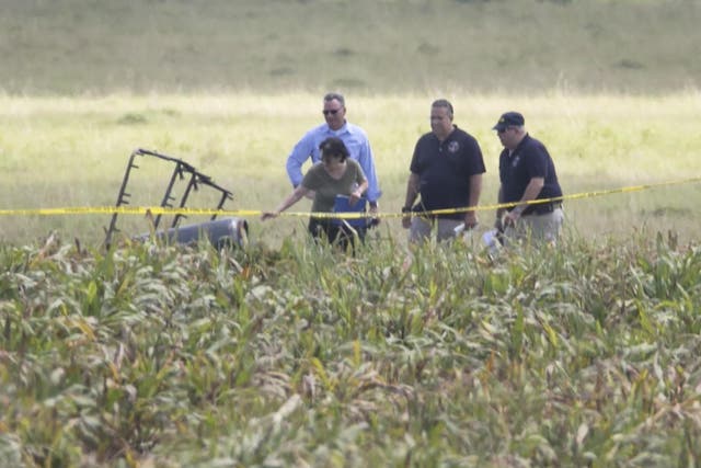 Investigators comb the wreckage of the crash in a field near Lockhart in Central Texas