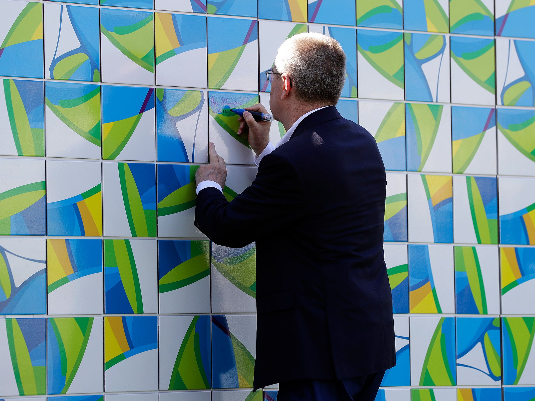 Thomas Bach signs the Olympic Wall in Rio on Tuesday