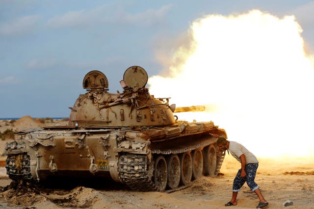 A fighter of Libyan forces allied with the UN-backed government fires a shell with Soviet made T-55 tank at Isis fighters in Sirte 