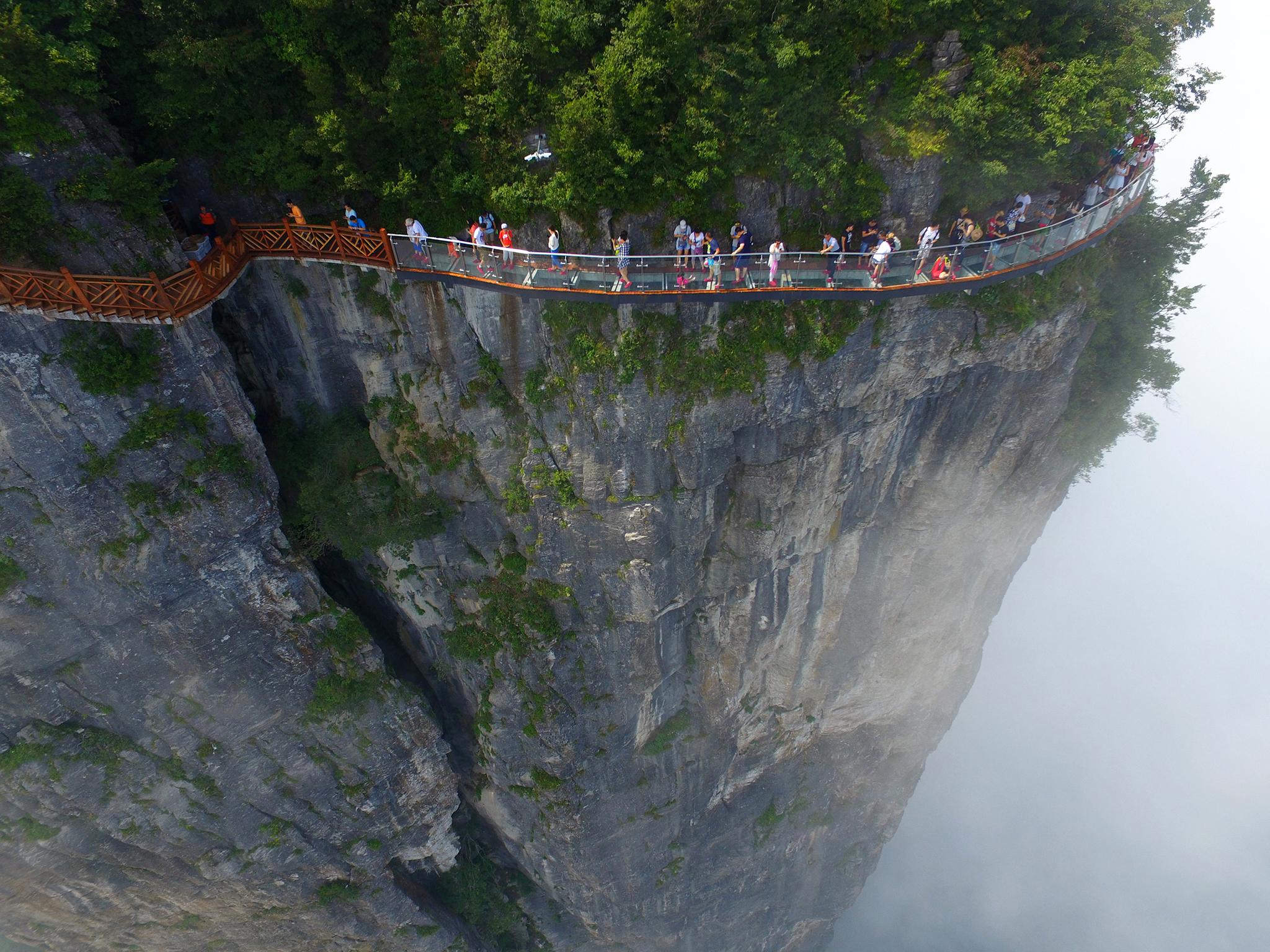 An aerial view of tourists walking on a glass-bottomed skywalk on the Panlong (coiling dragon) Cliff on Tianmen Mountain in Zhangjiajie, Hunan Province, China