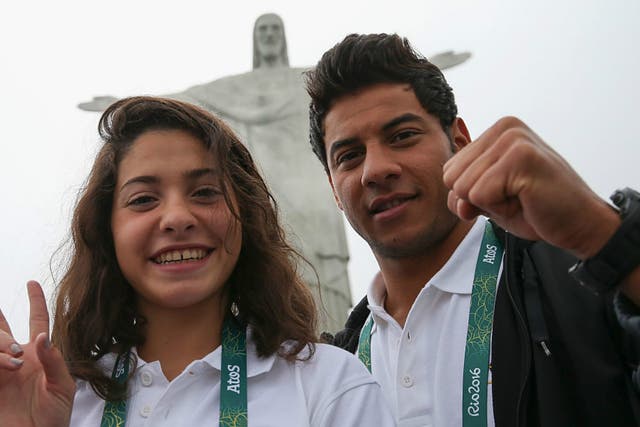 Olympic refugee team swimmers Yusra Mardini (L) and Rami Anis pose for a photo in front of the Christ the Redeemer statue on July 30, 2016 in Rio de Janeiro, Brazil.