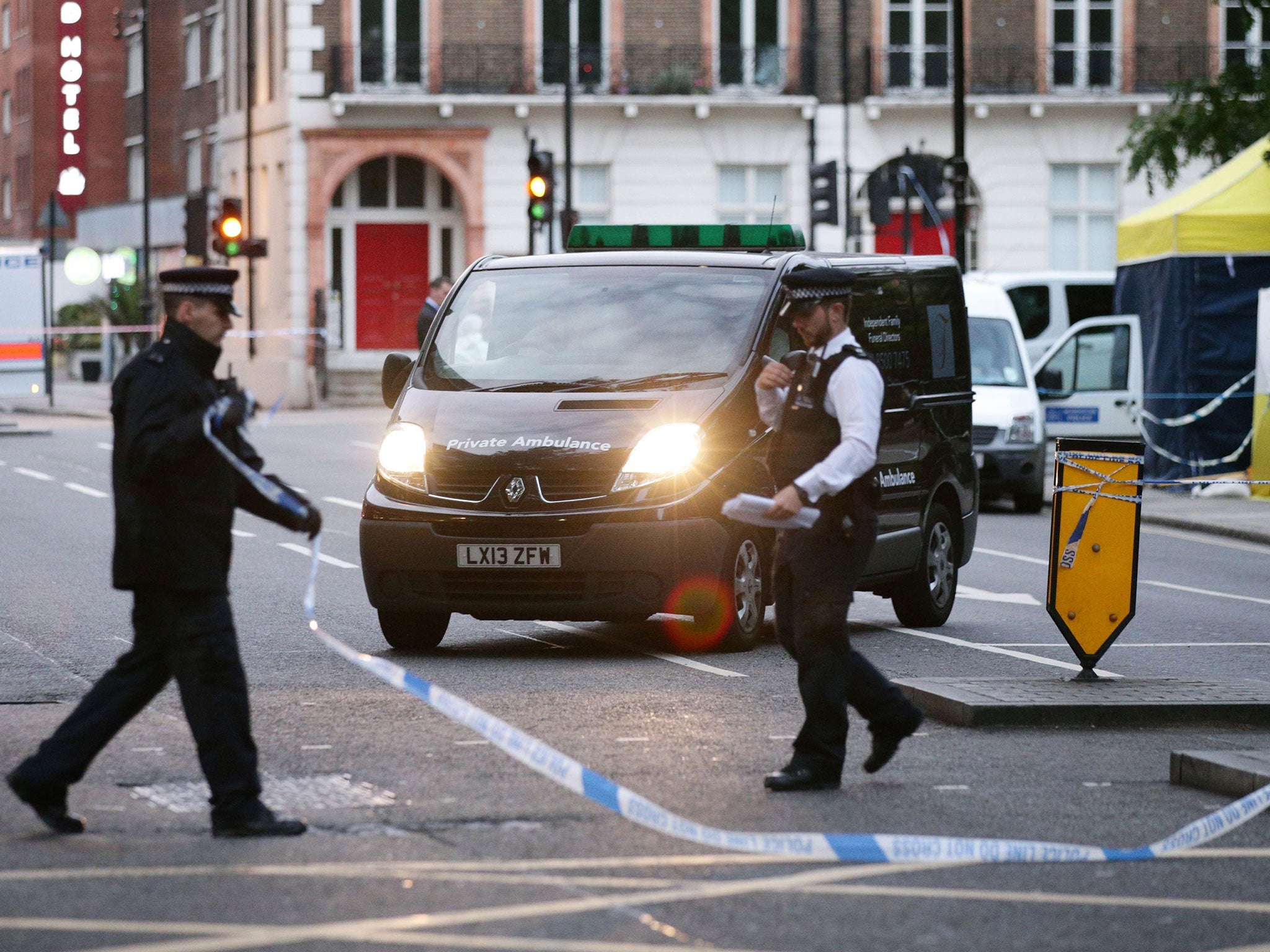 A body is driven away in a private ambulance from the scene in Russell Square, central London, after a knife attack in which a woman in her 60s was killed and five people were injured