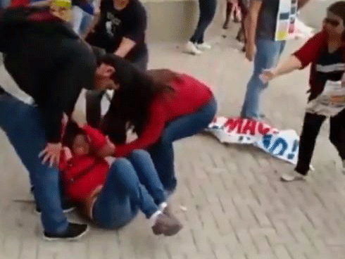 The young woman suddenly falls to the ground after a police officer lifts his gun at her