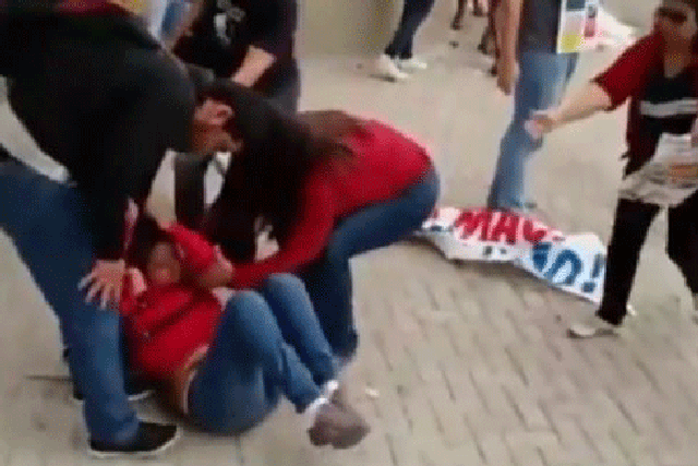 The young woman suddenly falls to the ground after a police officer lifts his gun at her