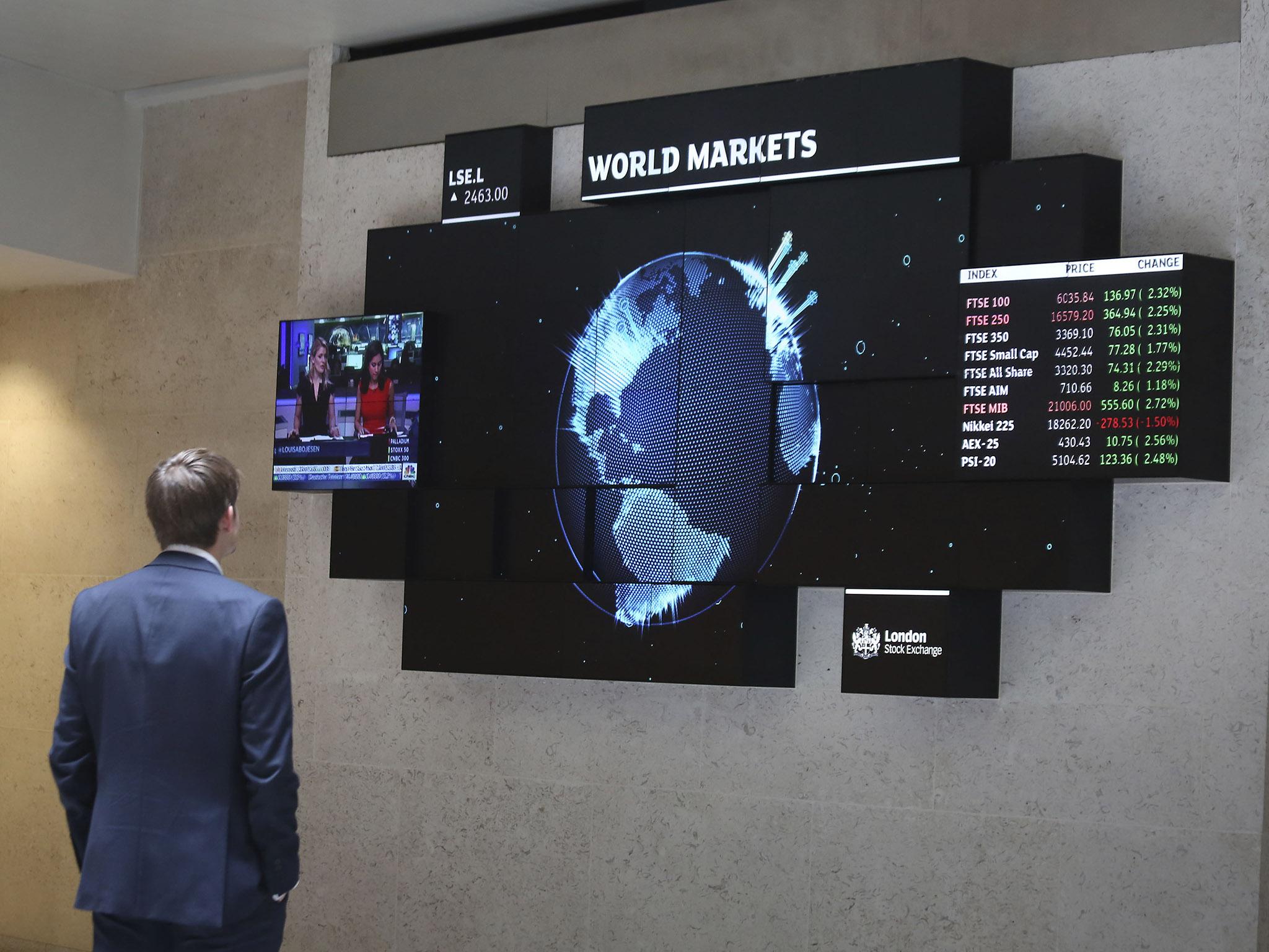 A city worker looking at a stock ticker screen at the London Stock Exchange, as profits at the LSE have been stung by costs associated with its attempted £21bn merger with Deutsche Börse