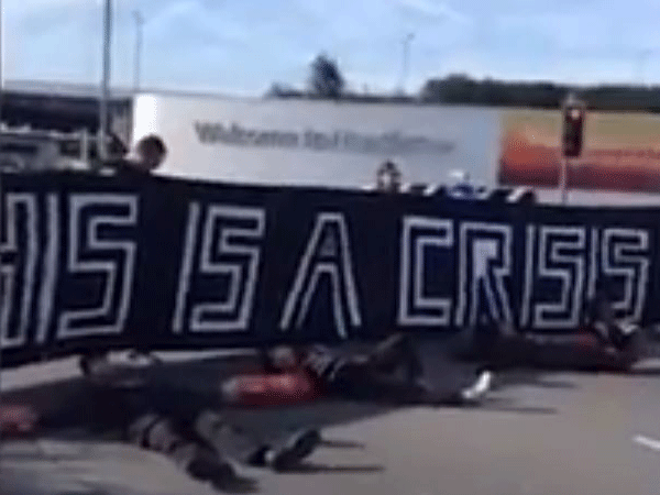 Protesters have unfurled a banner saying "This is a crisis"