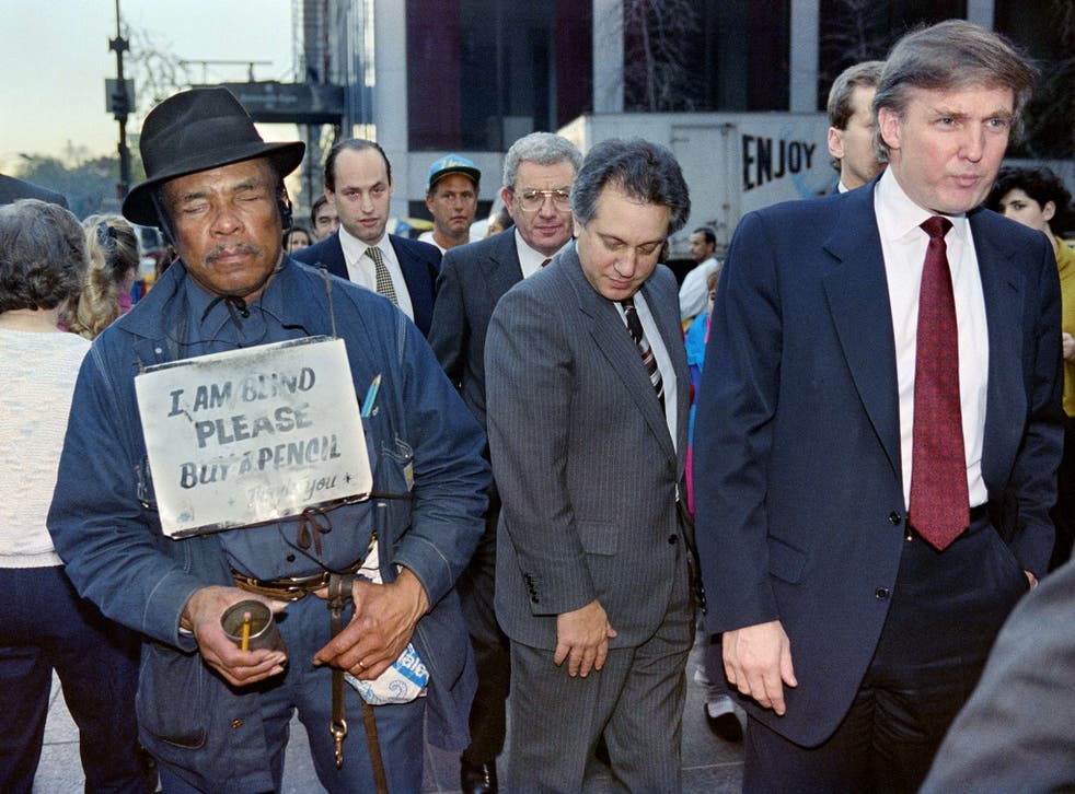 Donald Trump walks past a beggar in New York in 1990, after announcing he had reached a deal that would temporarily force his Taj Mahal casino into bankruptcy court