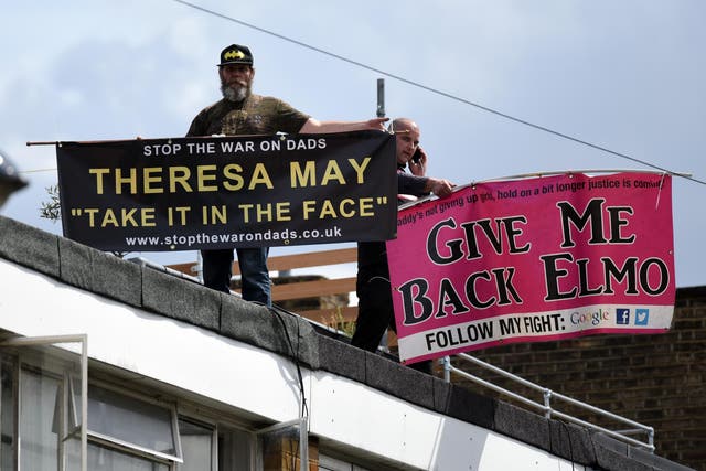 New Fathers 4 Justice campaigners hold banners as they protest on the roof of Labour leader Jeremy Corbyn's house