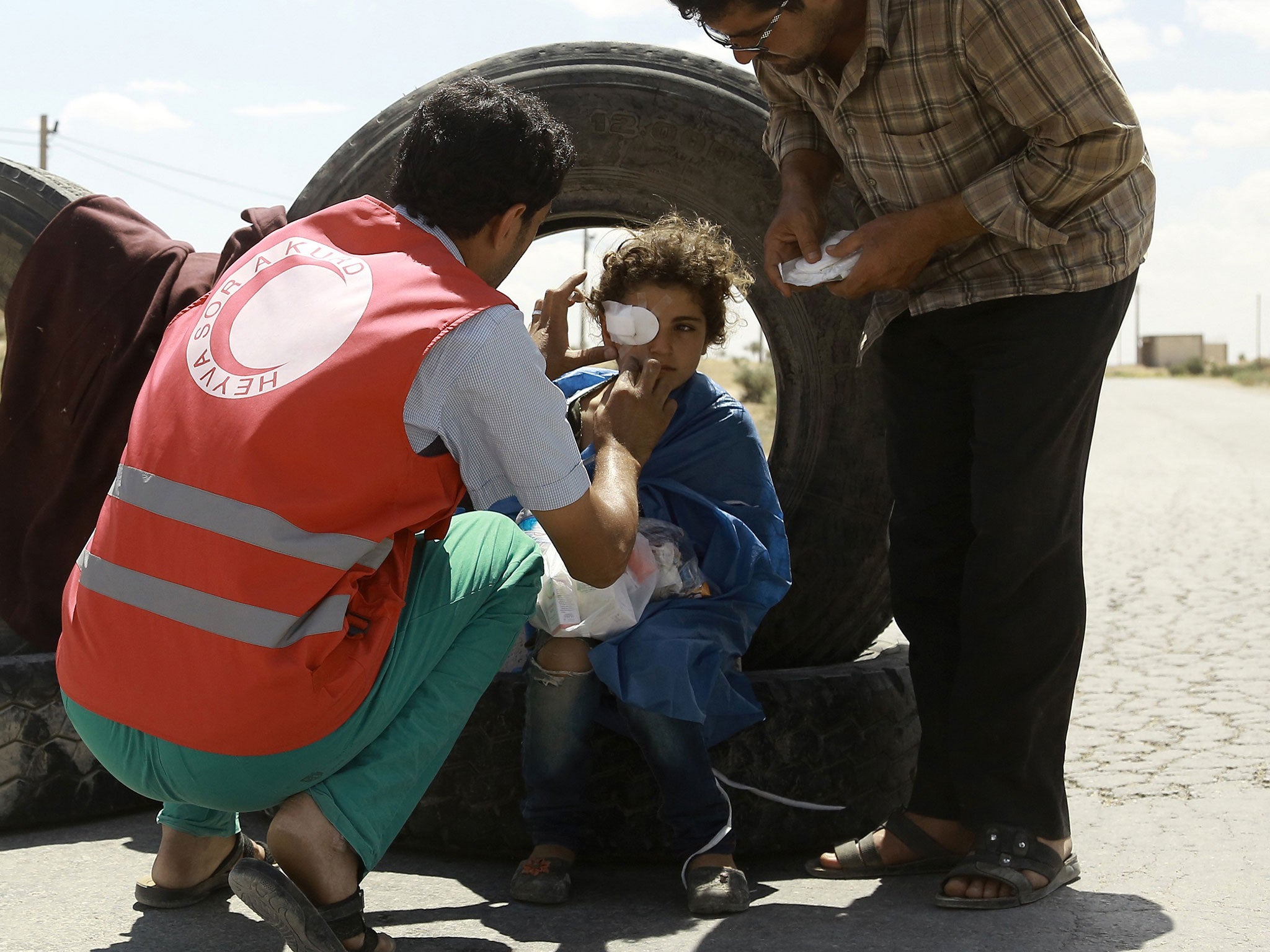 A young girl receives first aid for a shrapnel wound at a road block set up by fighters from the Syrian Democratic Forces (SDF) on 10 June, 2016 on the outskirts of the northern Syrian town of Manbij (AFP/Getty)