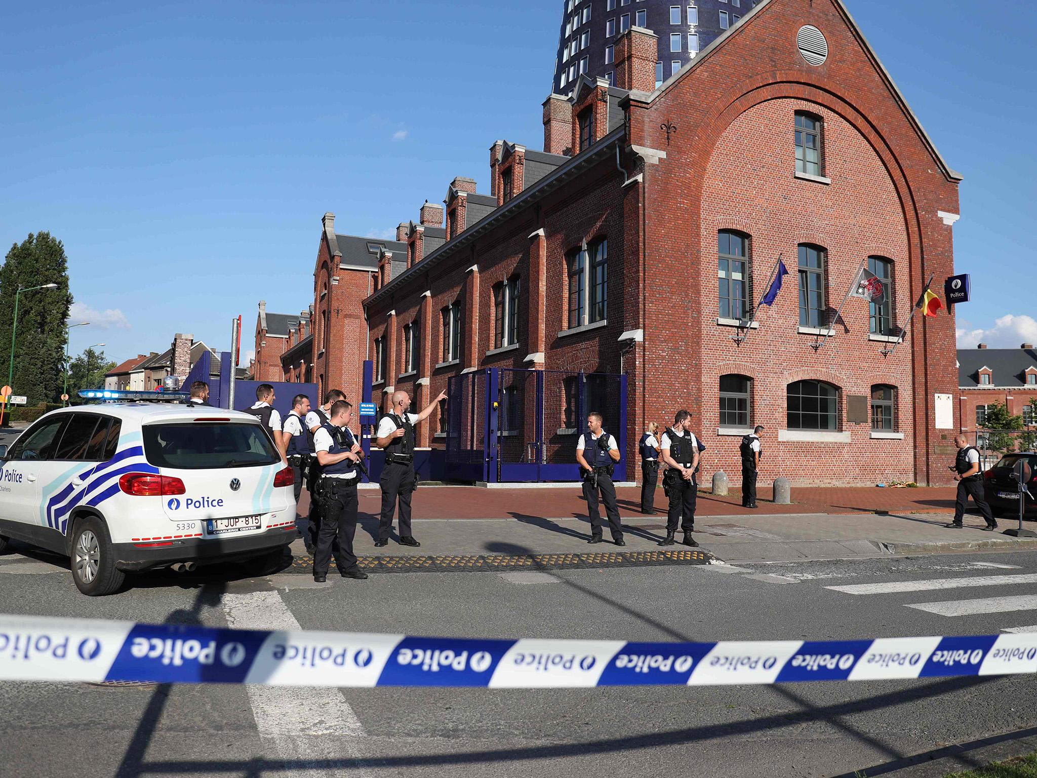 Police stand as they secure the area around a police building in the southern Belgian city of Charleroi following a machete attack